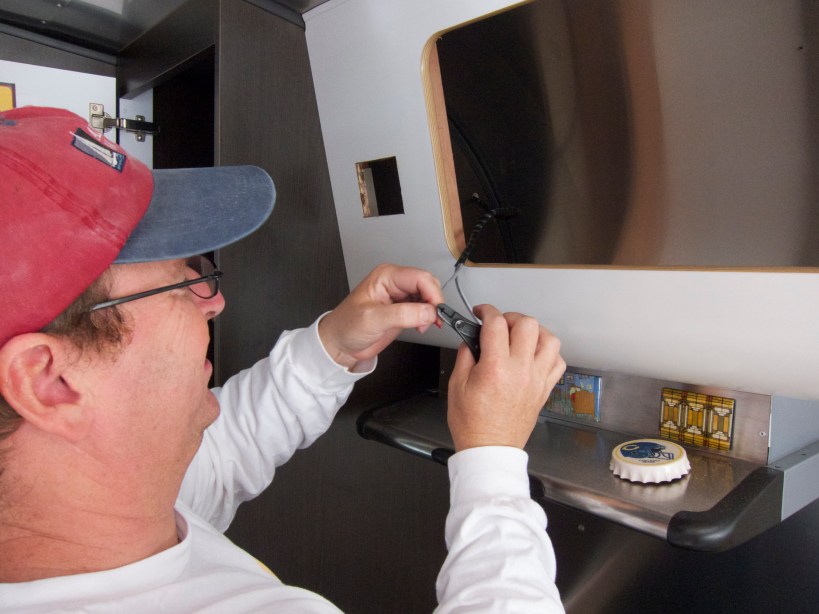 Tim preps the 18/2 wire which powers the remote panel.  Note the square hole for the panel