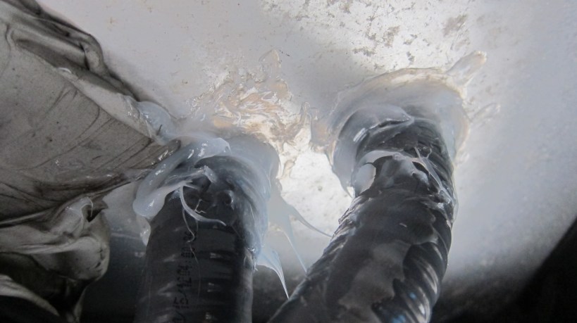 Flex PVC conduit enters the utility bay from the bottom exterior 